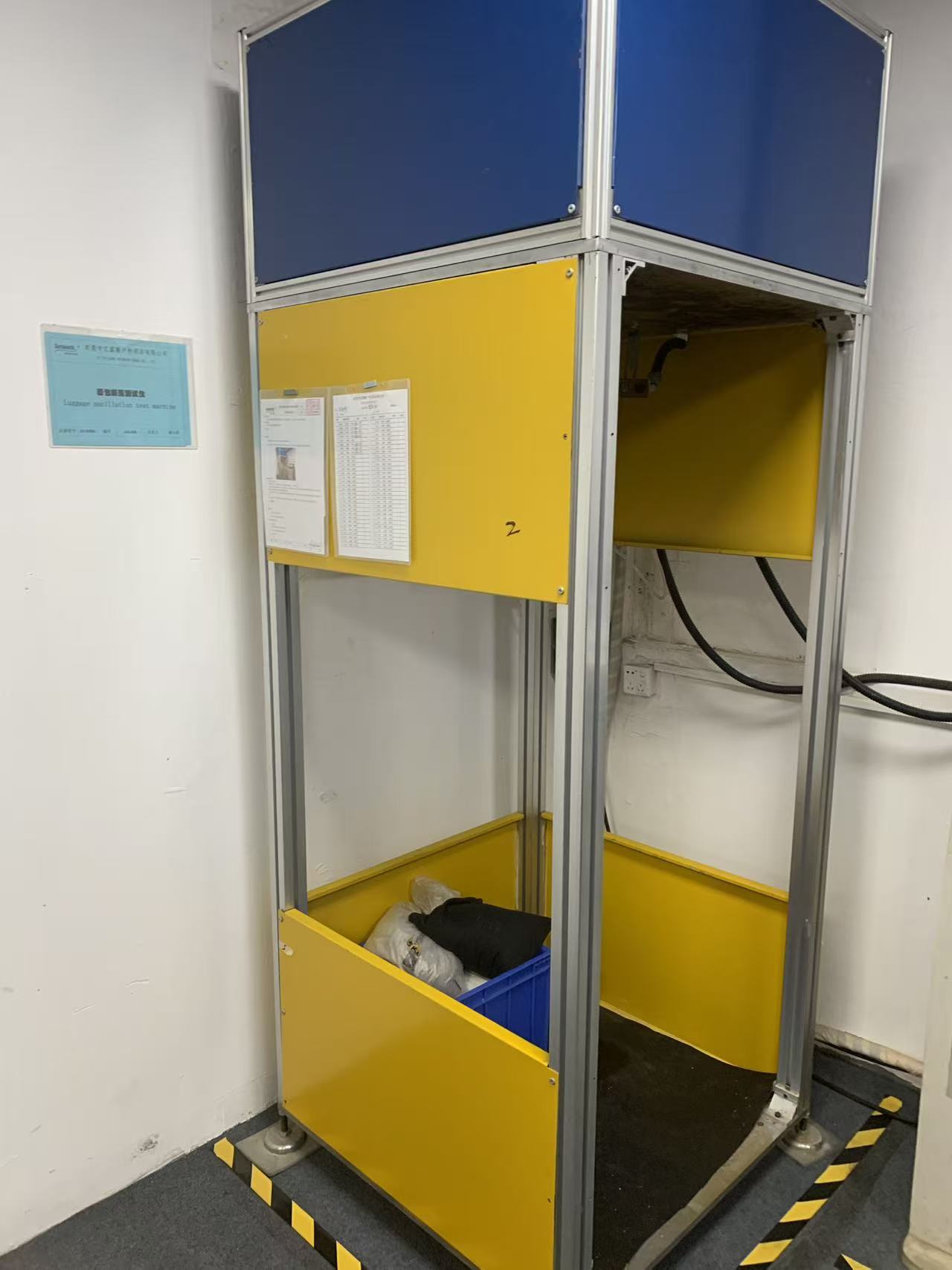 Luggage oscillation impact test machine XE-I09BA in the Sealock quality laboratory, aluminium profile cage with overhead impact head