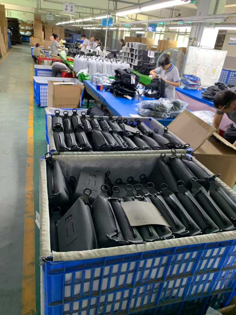 Packing bench with retail folding cartons, white drawstring dust bags and finished goods